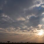 African sun bursts through cloudy sky