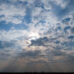 Fullframe sunbeams piercing cloudy sky