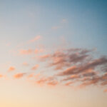 Warm sunset sky with small stripes of cloud