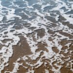 Water foam bubbles on the beach surface textured background