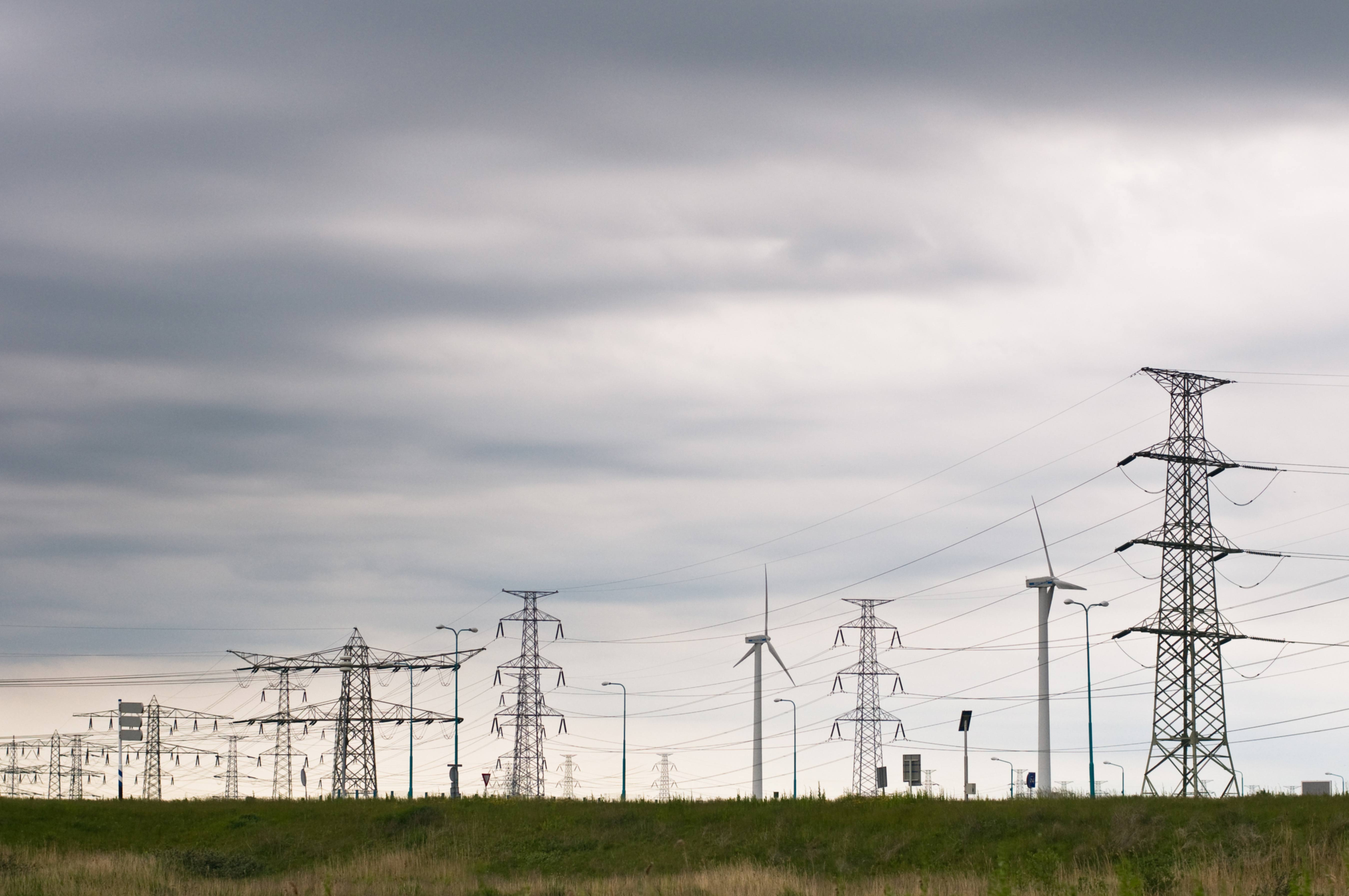 Grey clouds electricity wires and wind turbines