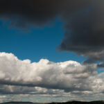 White and dark grey clouds with blue sky