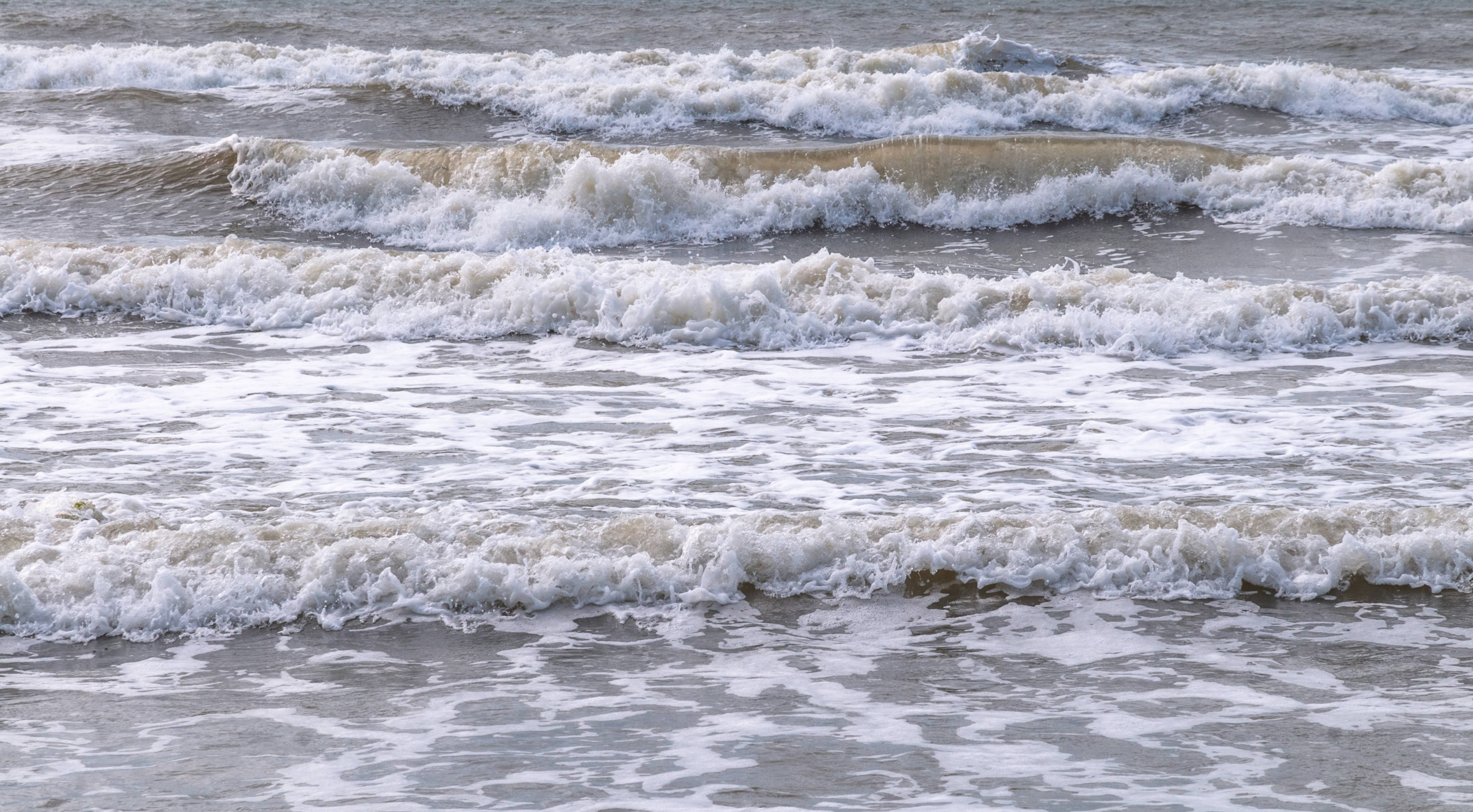 Foam waves at the beach sea free background photo