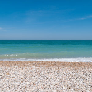 Summer blue sky ocean and pebble beach