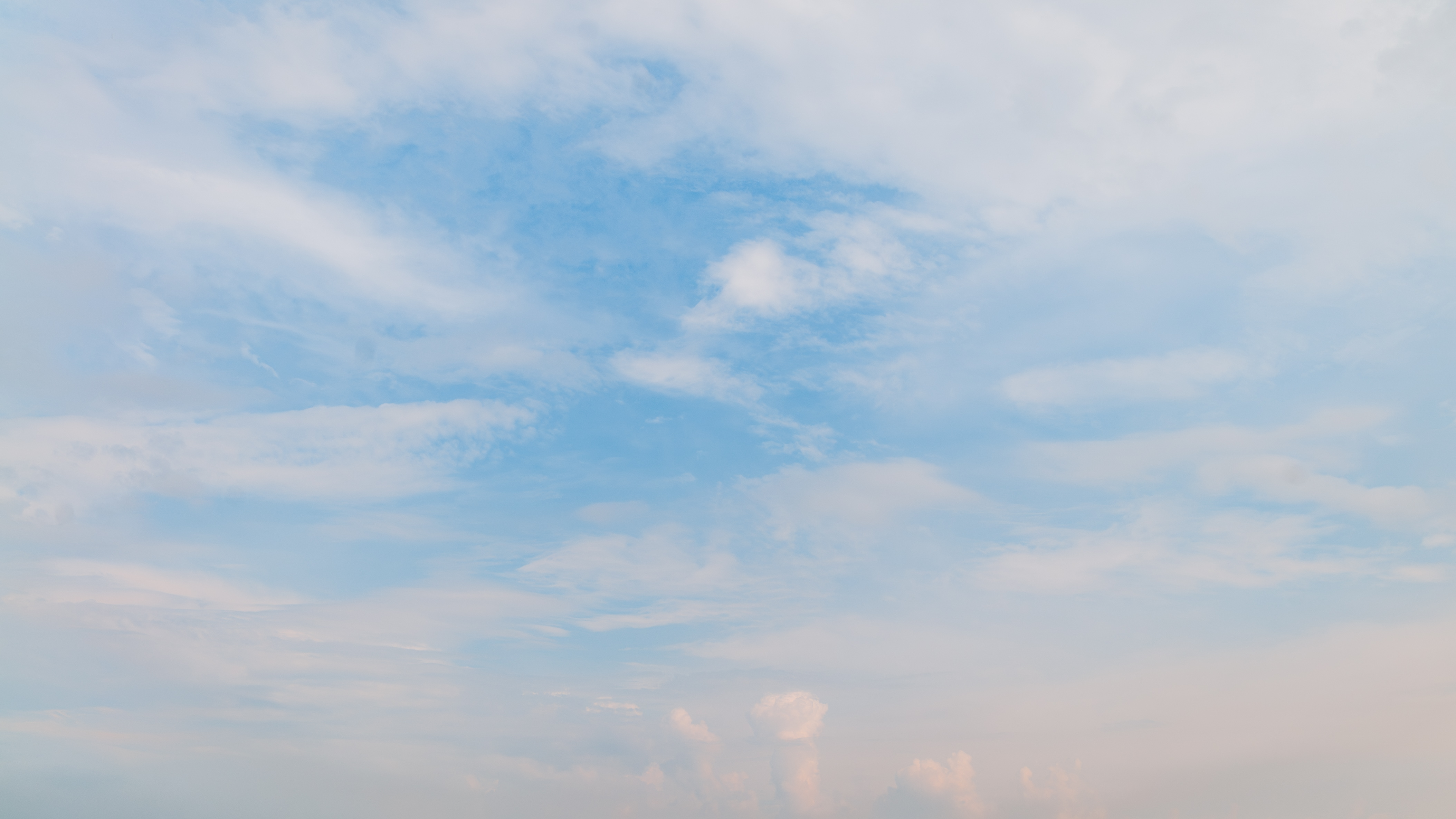 Blue sky surrounded by subtle clouds